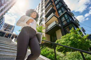 Smiling curly woman walking down the stairs